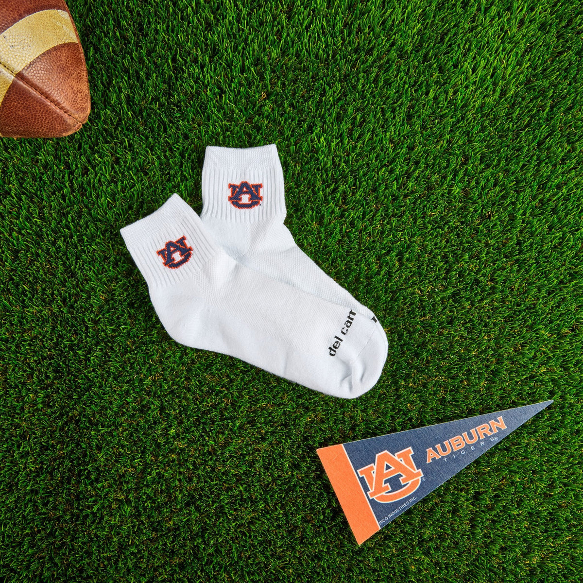 Del Campo Auburn War Eagle golf socks on turf with a team pennant