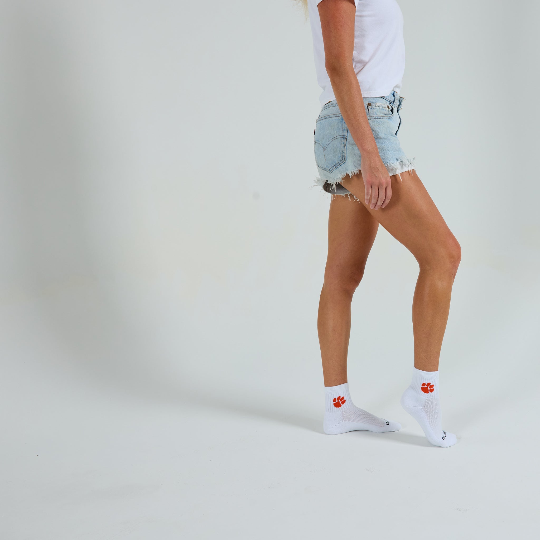 Woman wearing Del Campo Clemson Tigers golf socks, studio shot, no shoes