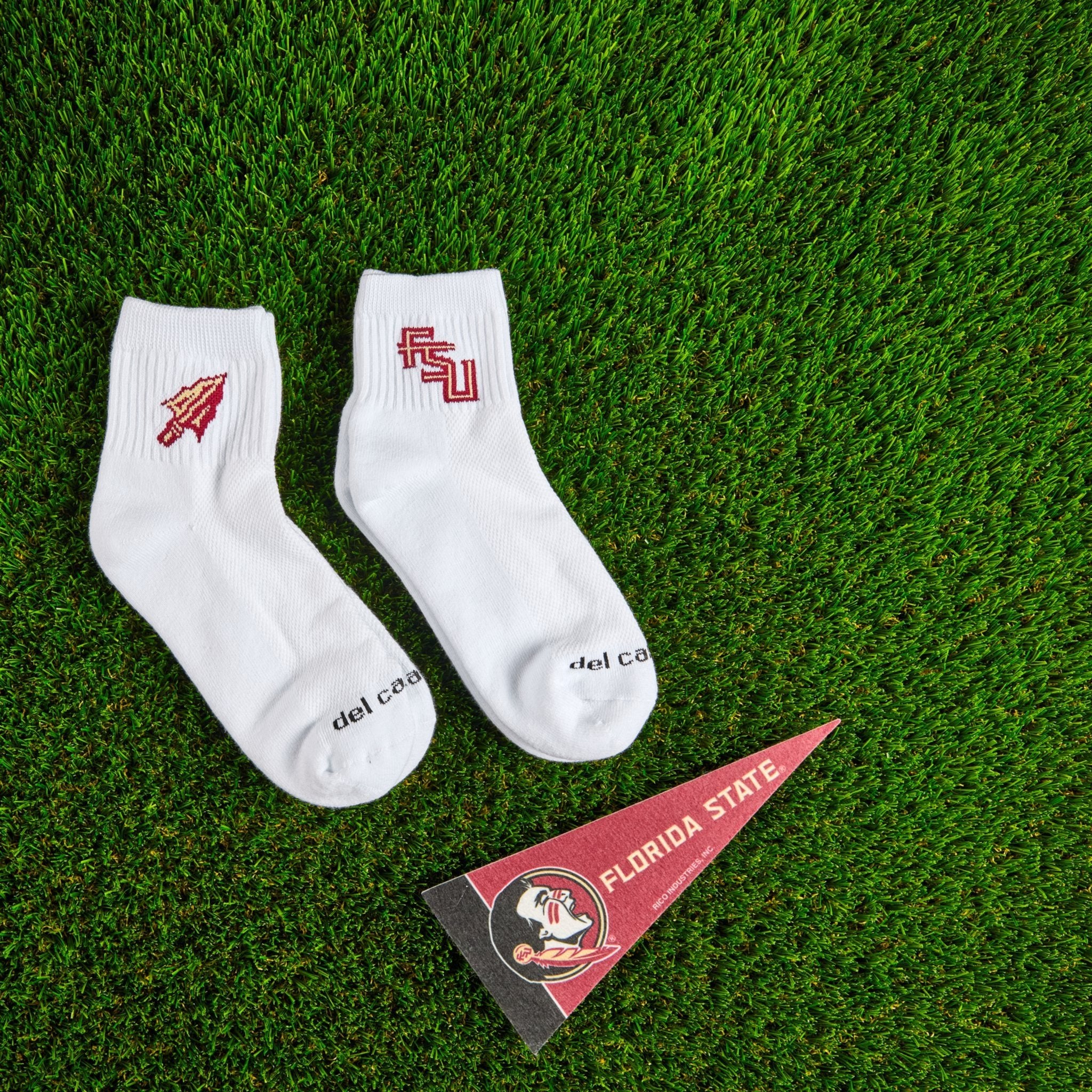 Del Campo Florida State Pack golf socks on turf with a team pennant