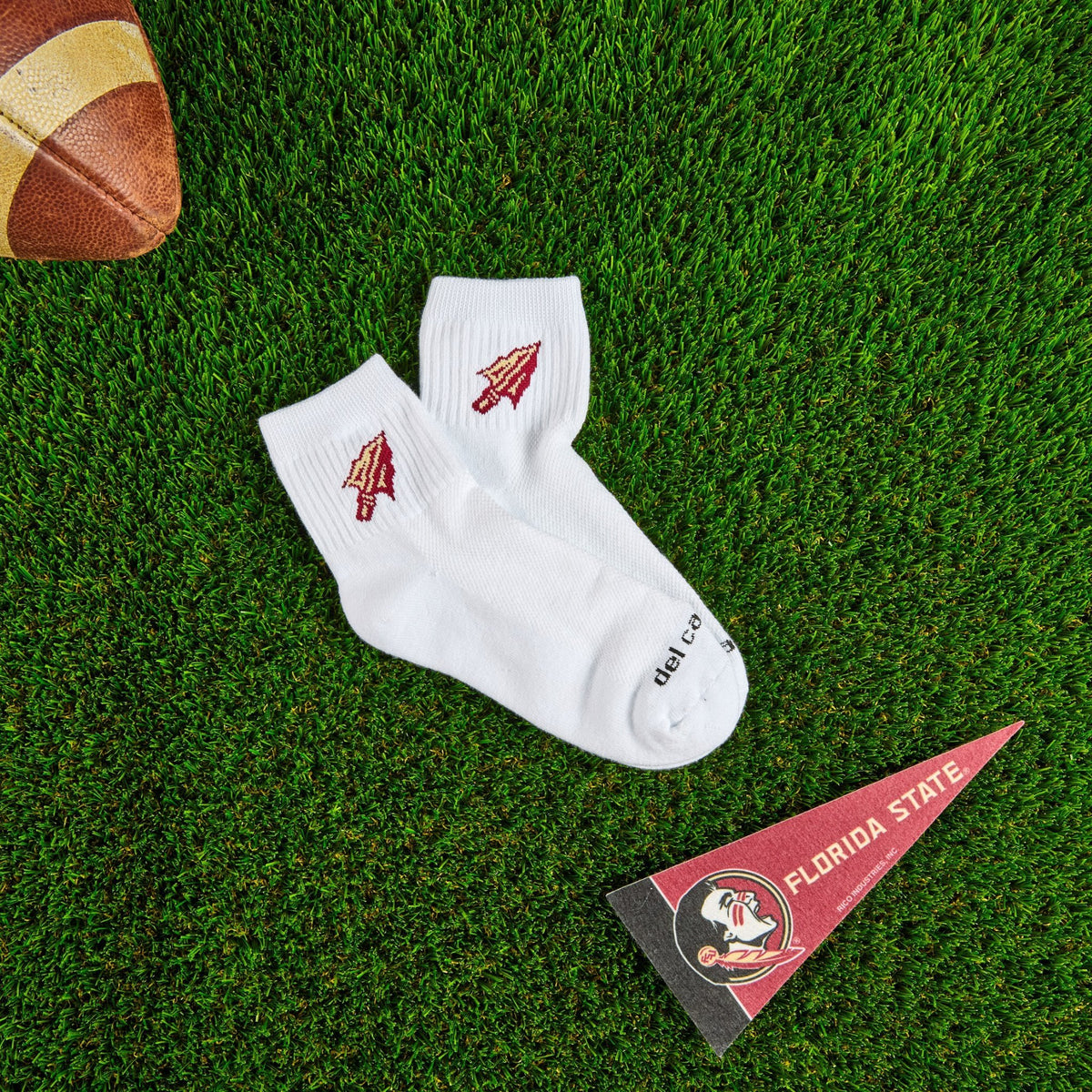 Del Campo Florida State Spear golf socks on turf with a team pennant