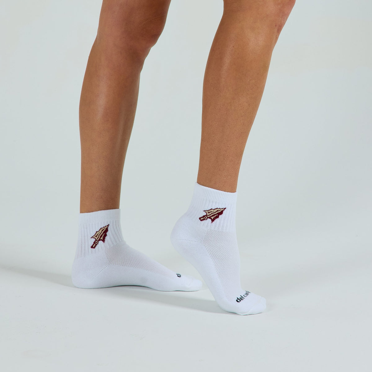 Woman wearing Del Campo Florida State Spear golf socks, studio shot, no shoes