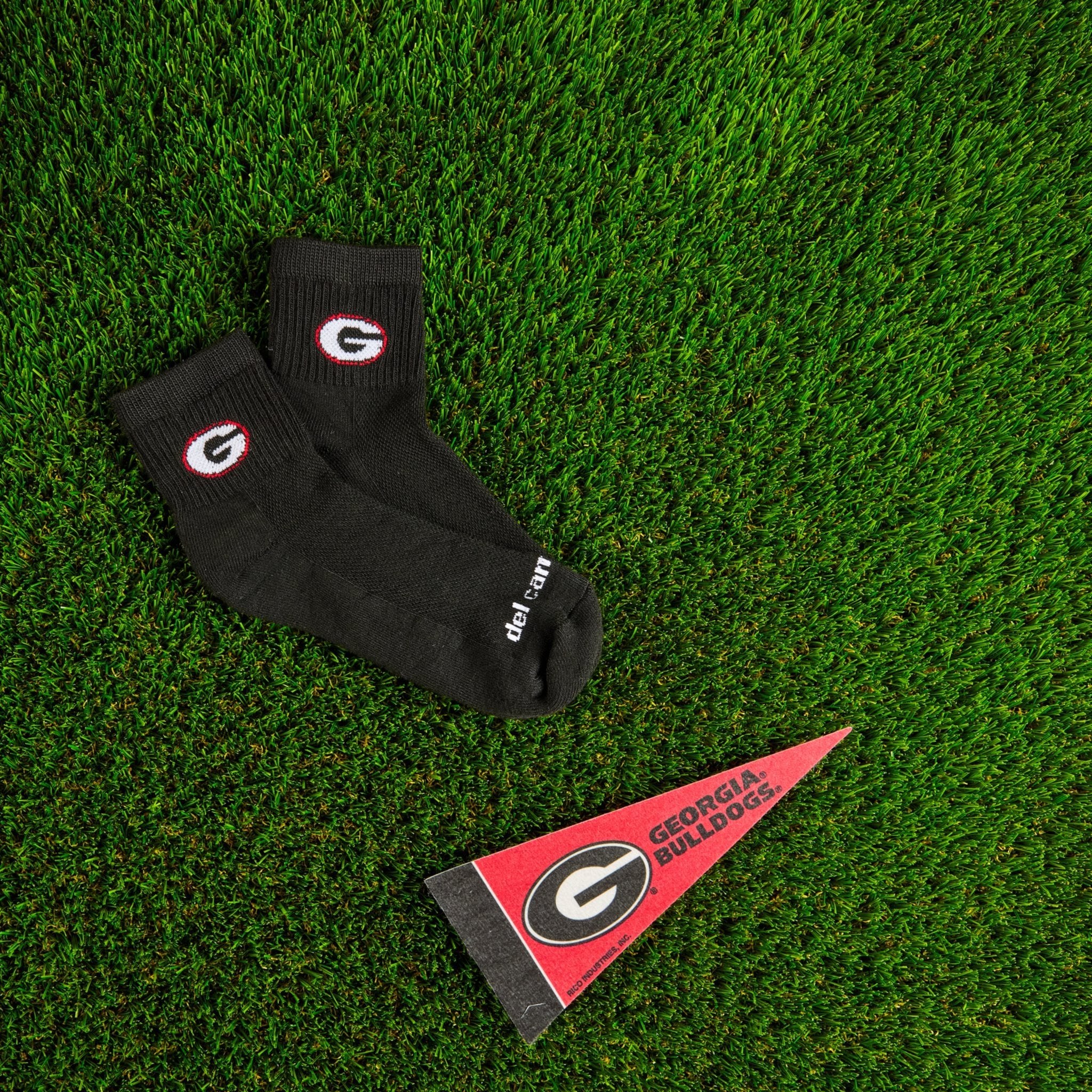 Del Campo Georgia Night Mode golf socks on turf with a team pennant