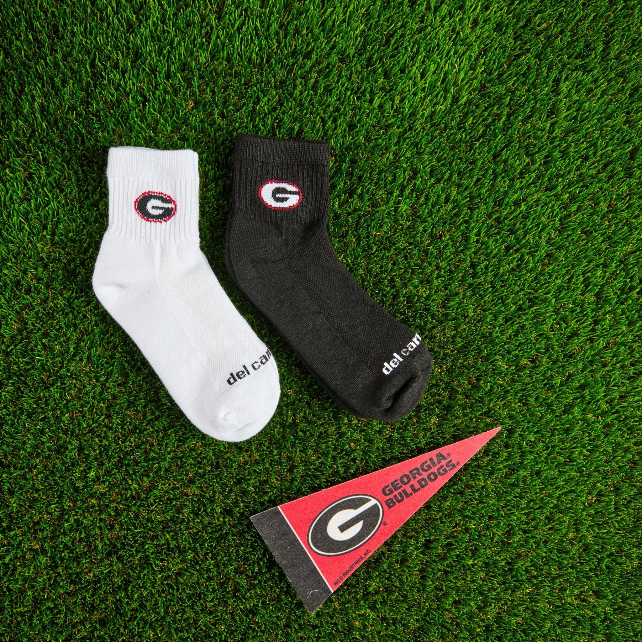 Del Campo Georgia Pack golf socks on turf with a team pennant