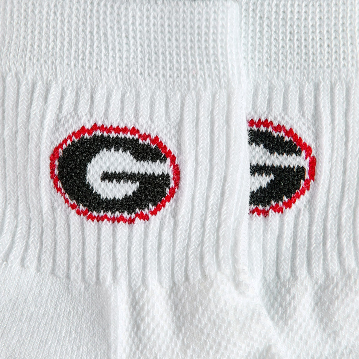 Close-up of the black G in a red oval on Del Campo Georgia Pack golf socks