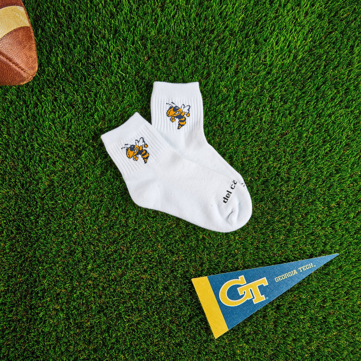 Del Campo Georgia Tech Buzz golf socks on turf with a team pennant