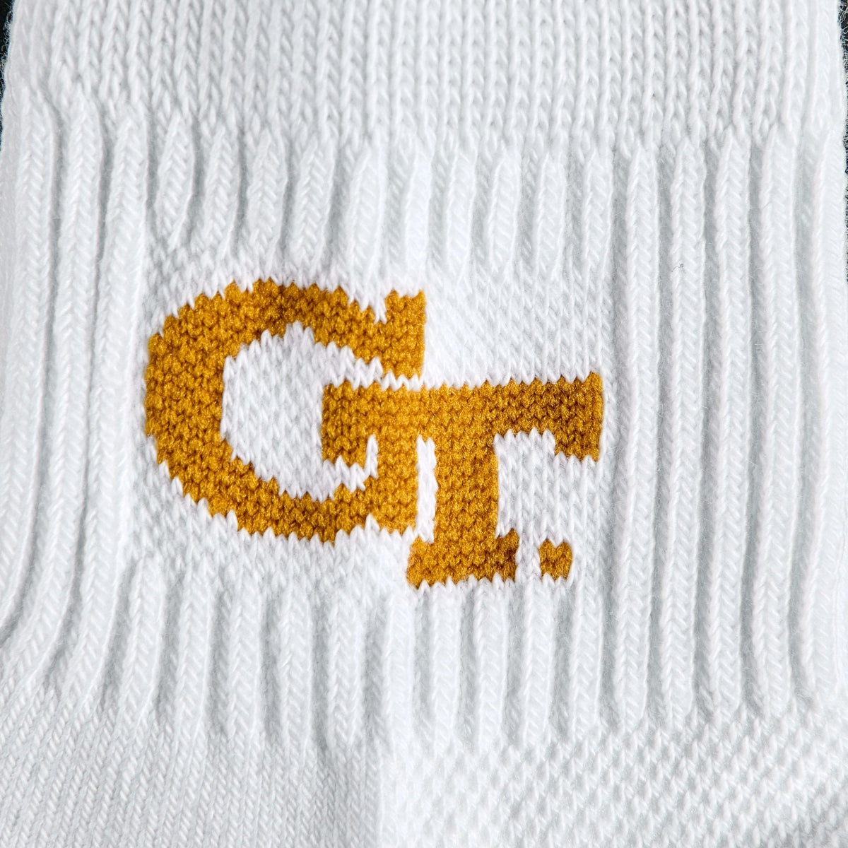 Close-up of the old gold GT interlock wordmark on Del Campo Georgia Tech GT golf socks