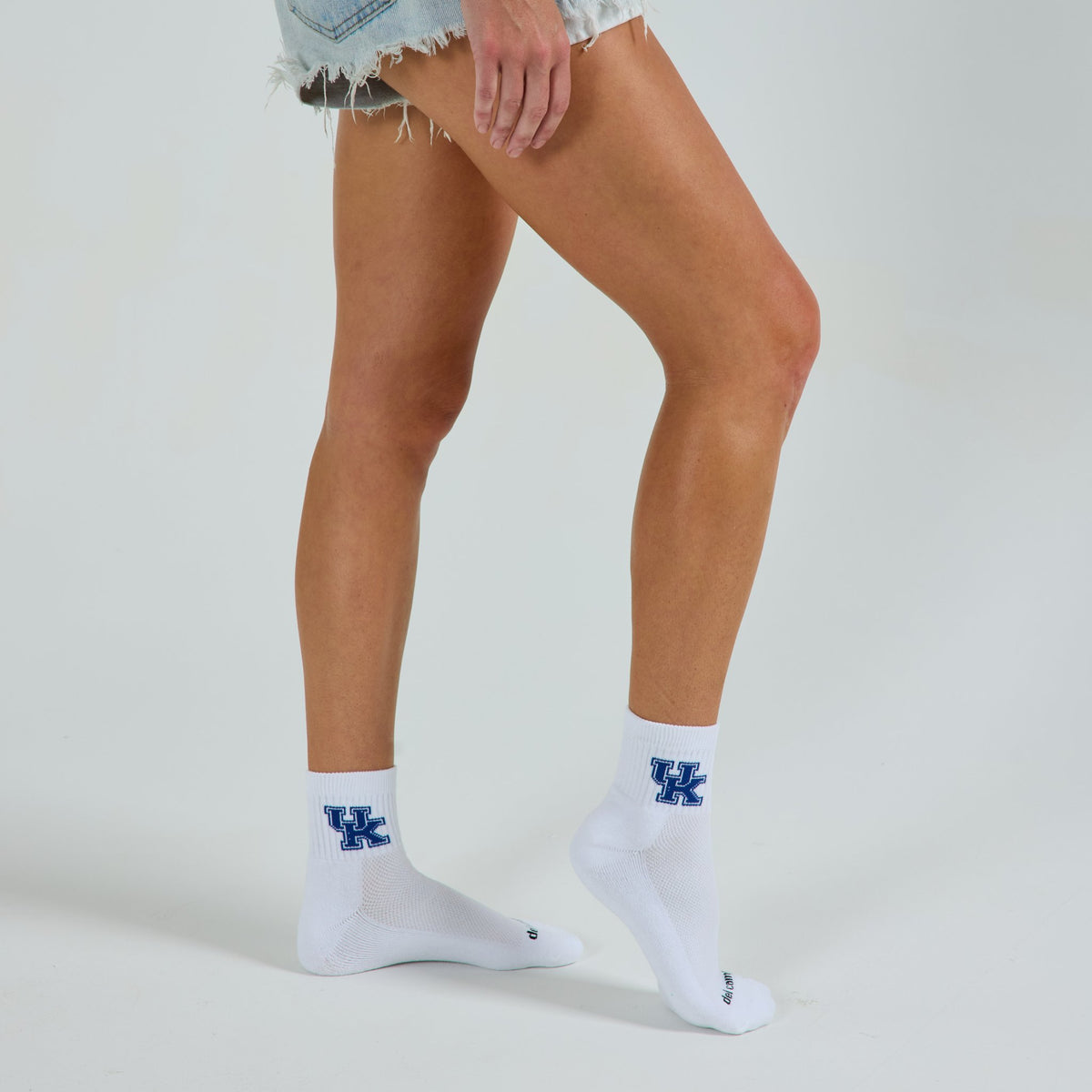Woman wearing Del Campo Kentucky Wildcats golf socks, studio shot, no shoes