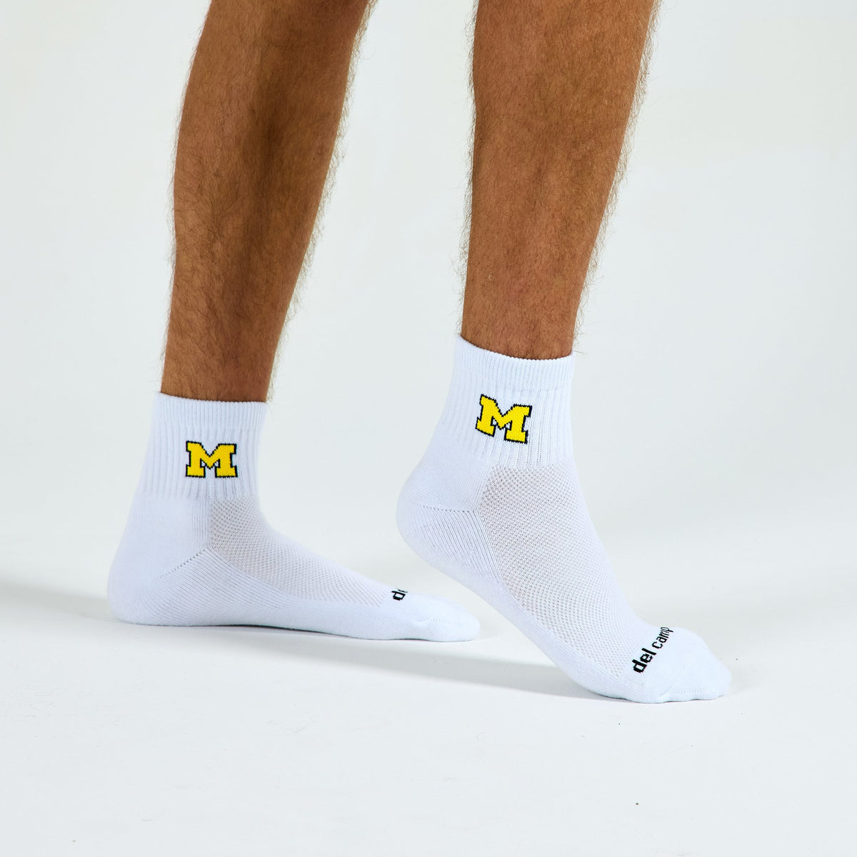 Man wearing Del Campo Michigan Maize golf socks, studio shot, no shoes
