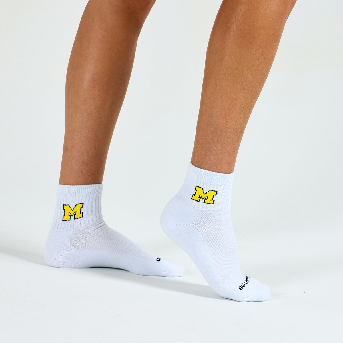 Woman wearing Del Campo Michigan Maize golf socks, studio shot, no shoes