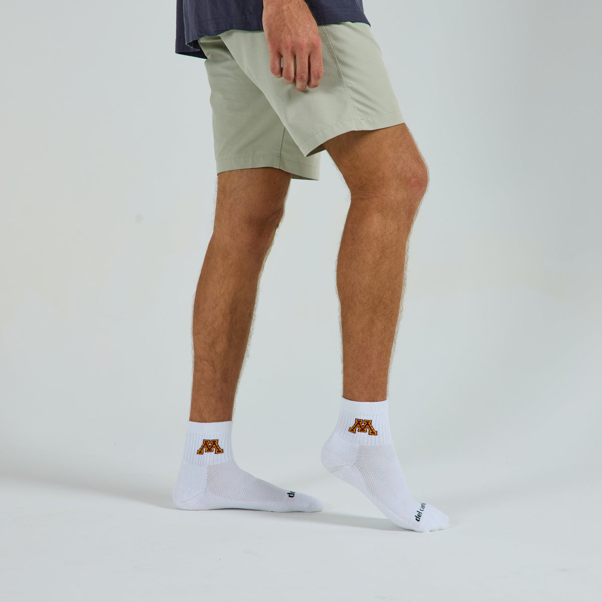 Man wearing Del Campo Minnesota Golden Gophers golf socks, studio shot, no shoes