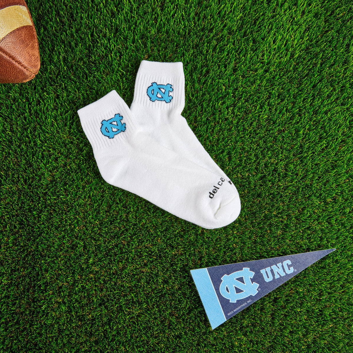 Del Campo North Carolina Interlocking NC golf socks on turf with a team pennant