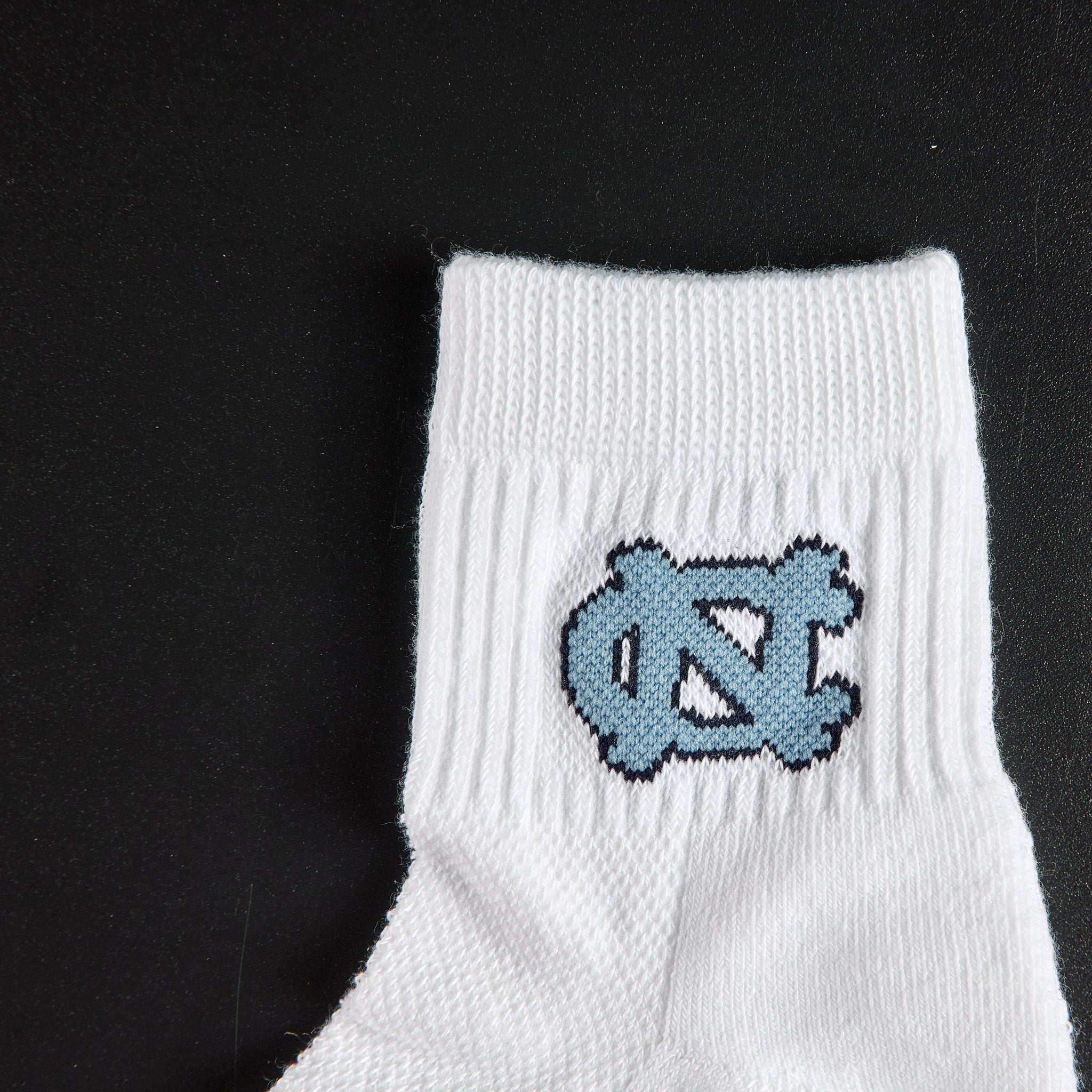 Close-up of the Carolina blue NC interlock on Del Campo North Carolina Interlocking NC golf socks