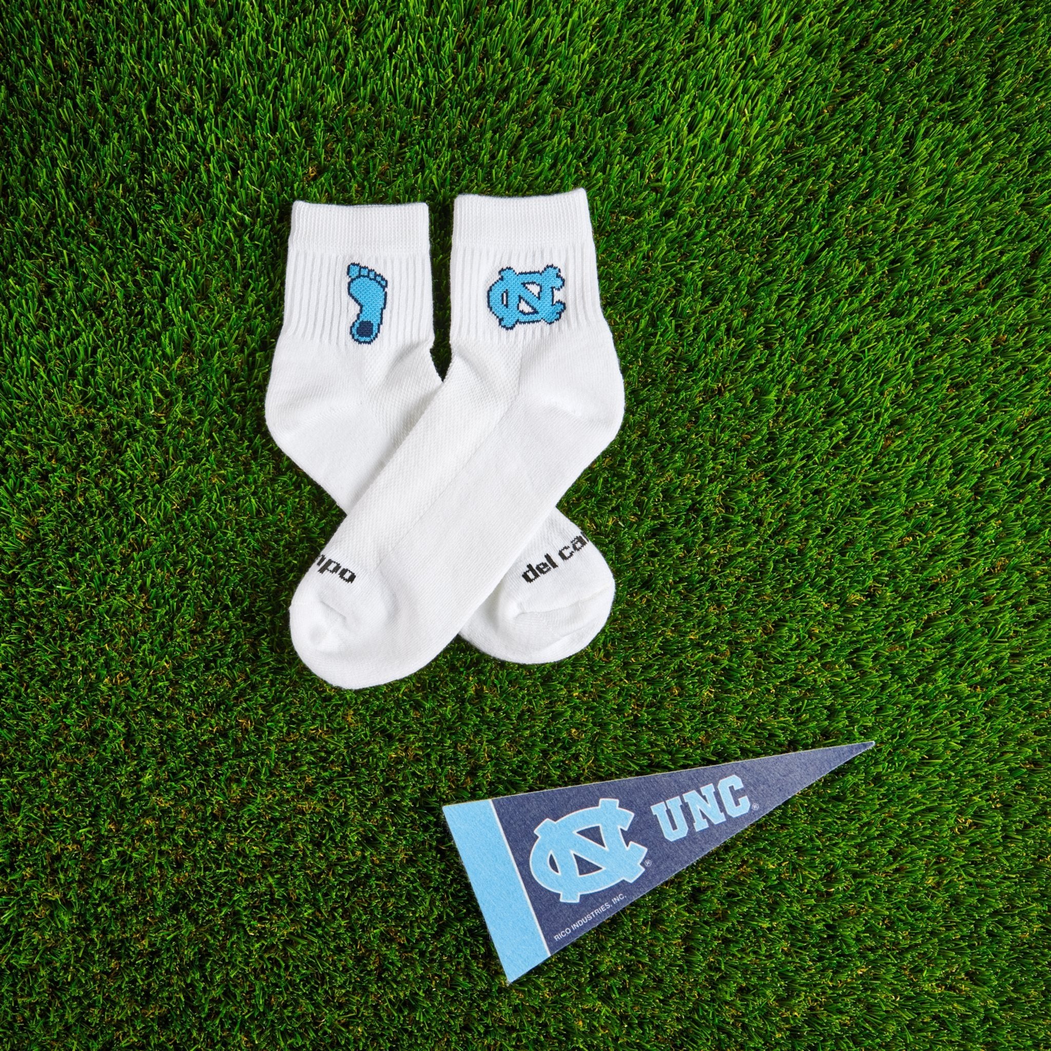 Del Campo North Carolina Tar Heel golf socks on turf with a team pennant