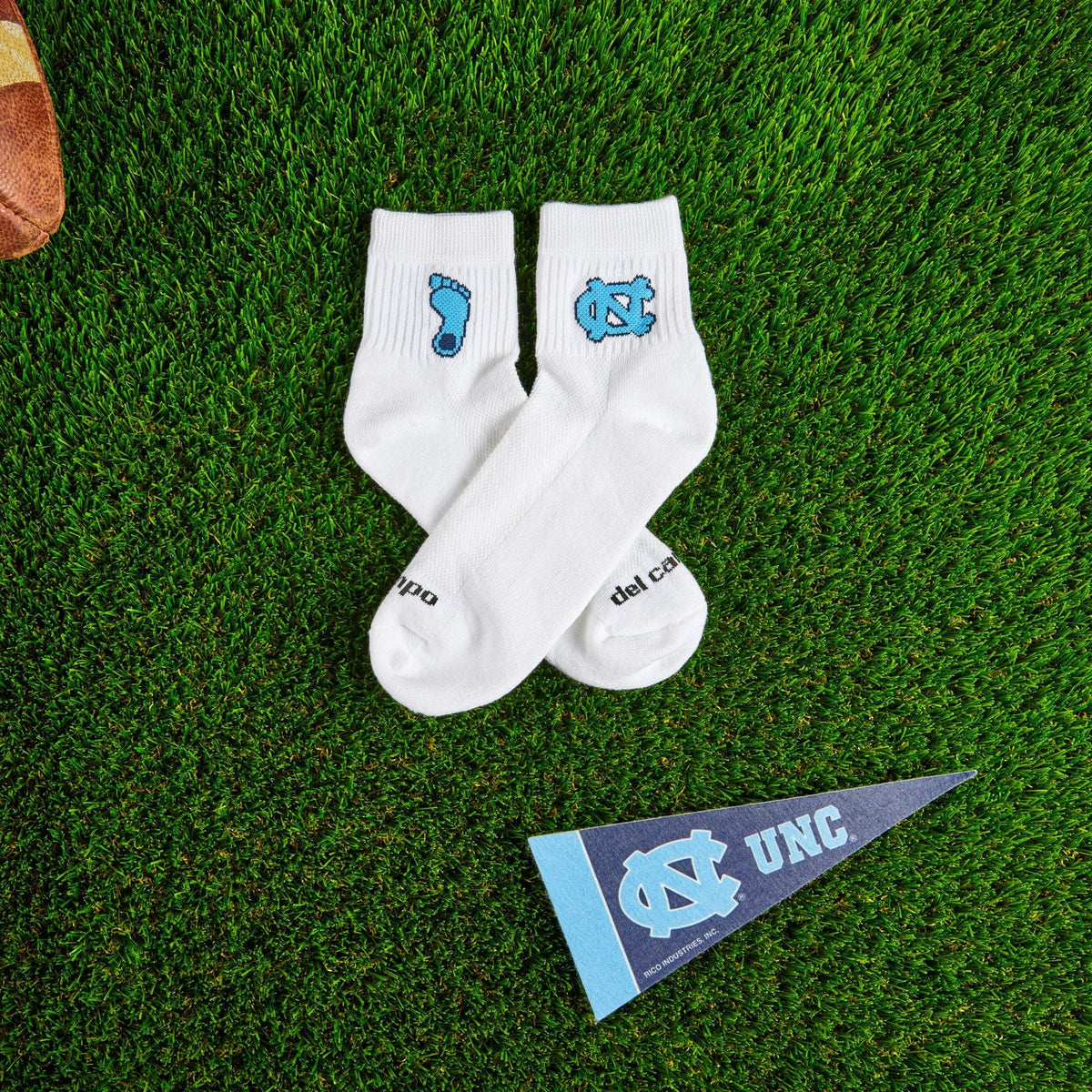 Del Campo North Carolina Tar Heel golf socks on turf with a team pennant