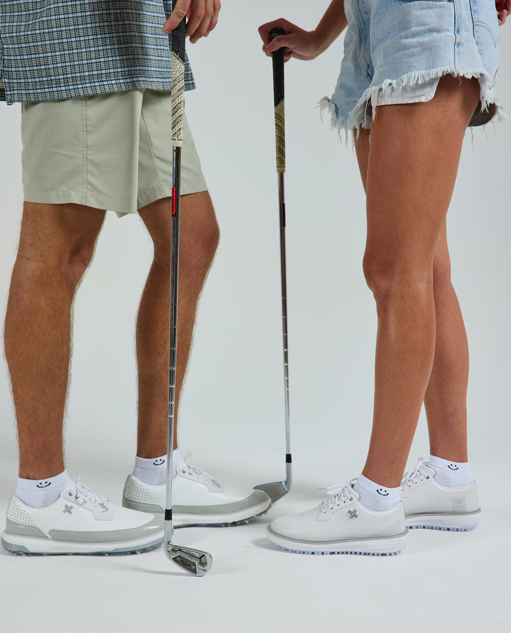 Smiley Lowcut Socks on two golfers in white golf shoes, vertical - del campo