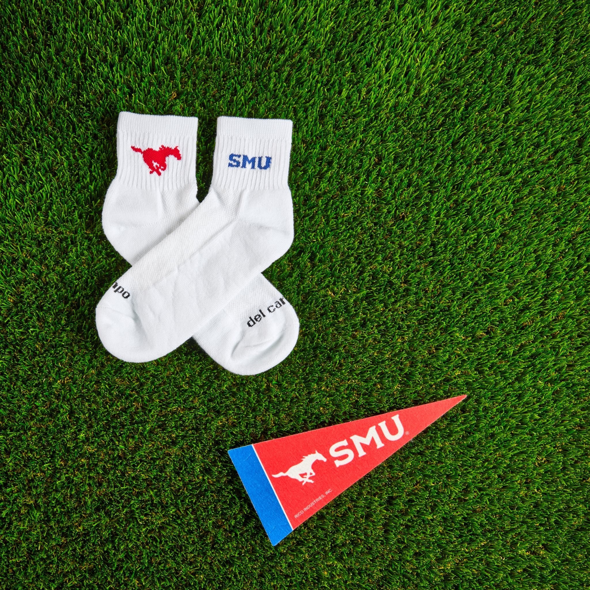 Del Campo SMU Mustangs golf socks on turf with a team pennant
