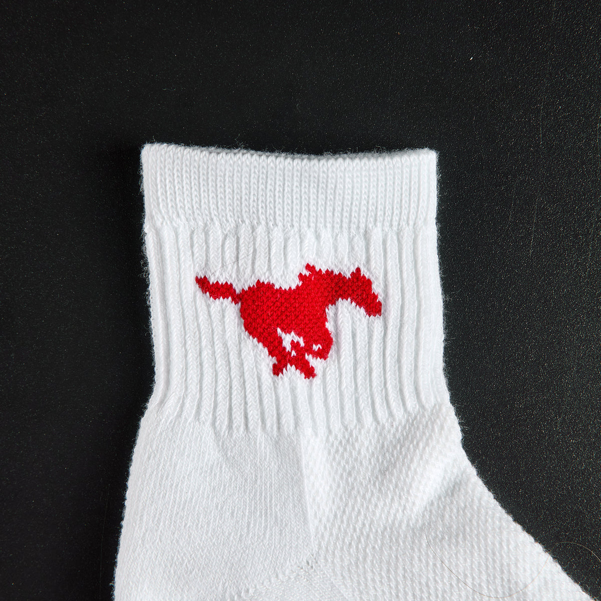 Close-up of the red running Mustang on Del Campo SMU Mustangs golf socks