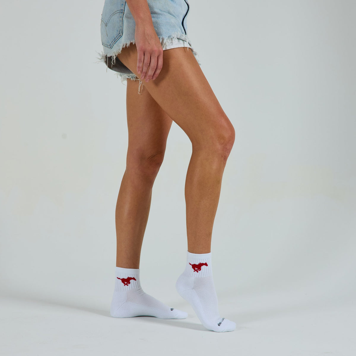 Woman wearing Del Campo SMU Mustangs golf socks, studio shot, no shoes
