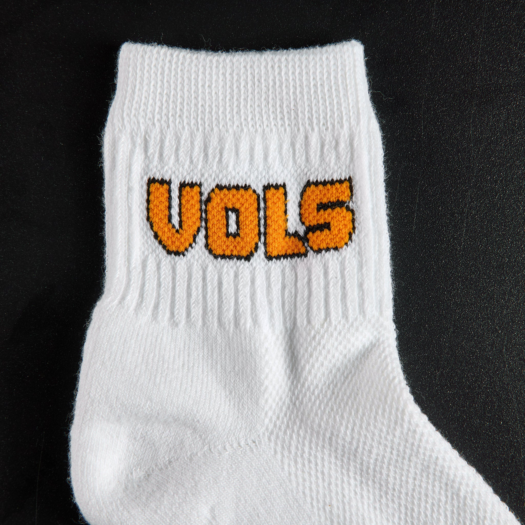 Close-up of the VOLS block wordmark on Del Campo Tennessee Block golf socks