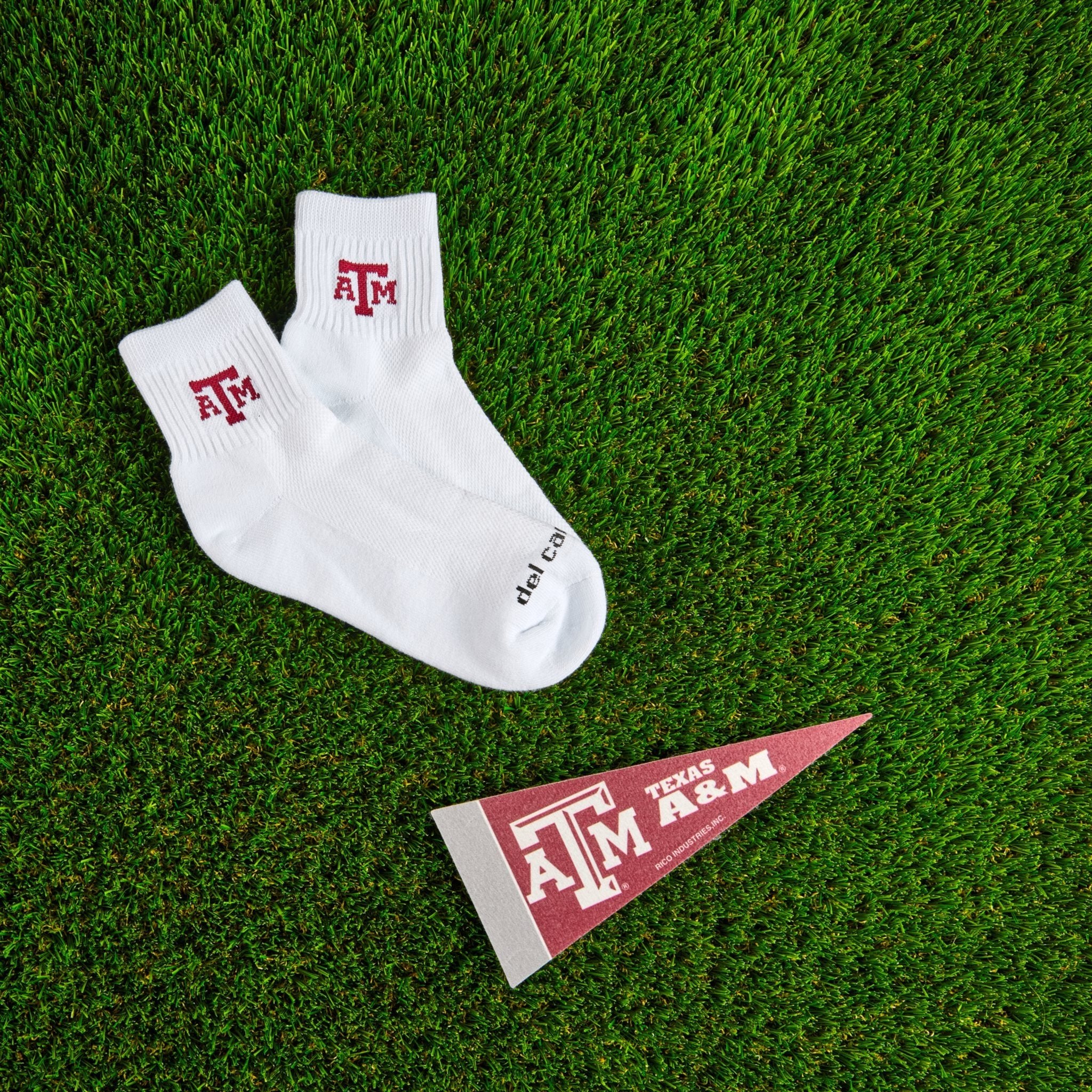 Del Campo Texas A&M Aggies golf socks on turf with a team pennant