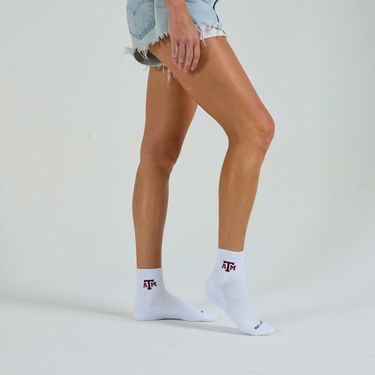 Woman wearing Del Campo Texas A&M Aggies golf socks, studio shot, no shoes