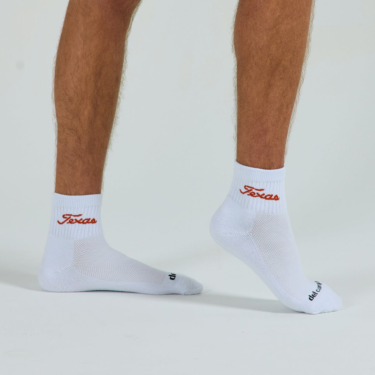Man wearing Del Campo Texas Longhorns Script golf socks, studio shot, no shoes