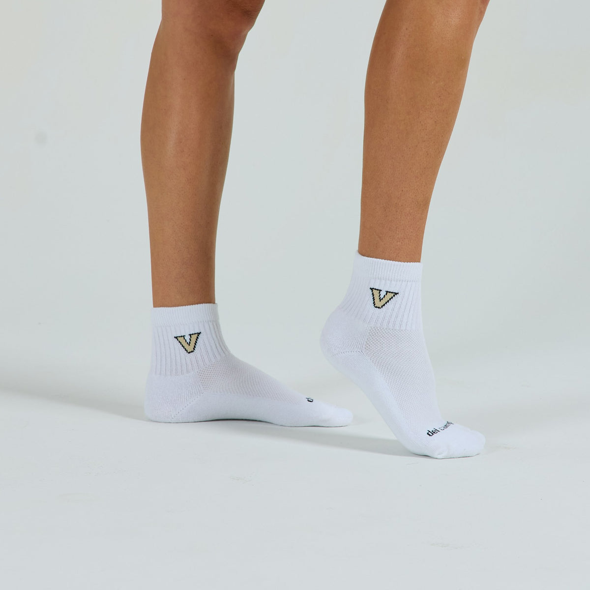 Woman wearing Del Campo Vanderbilt Commodores golf socks, studio shot, no shoes