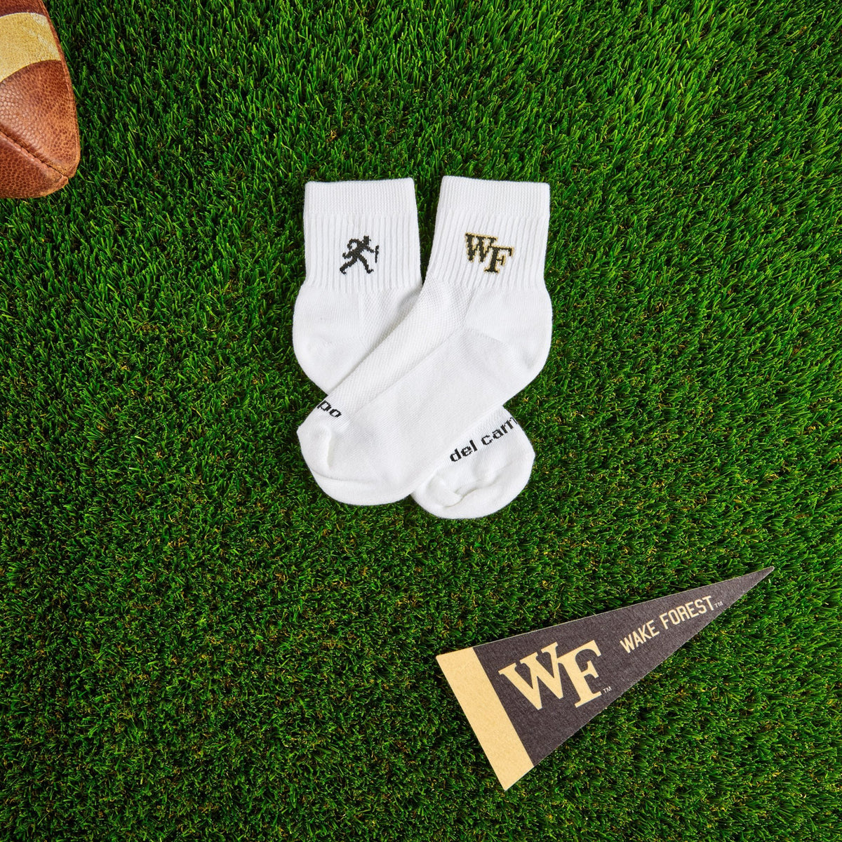 Del Campo Wake Forest Walking Deacon golf socks on turf with a team pennant