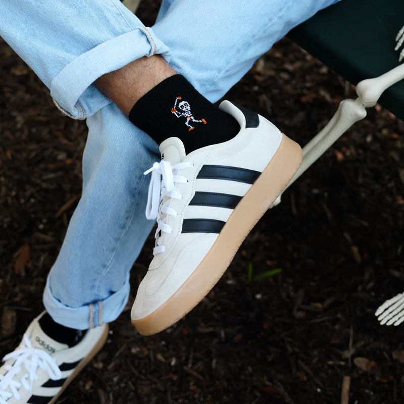 Swingin' Skelly sock with a sneaker and a skeleton hand