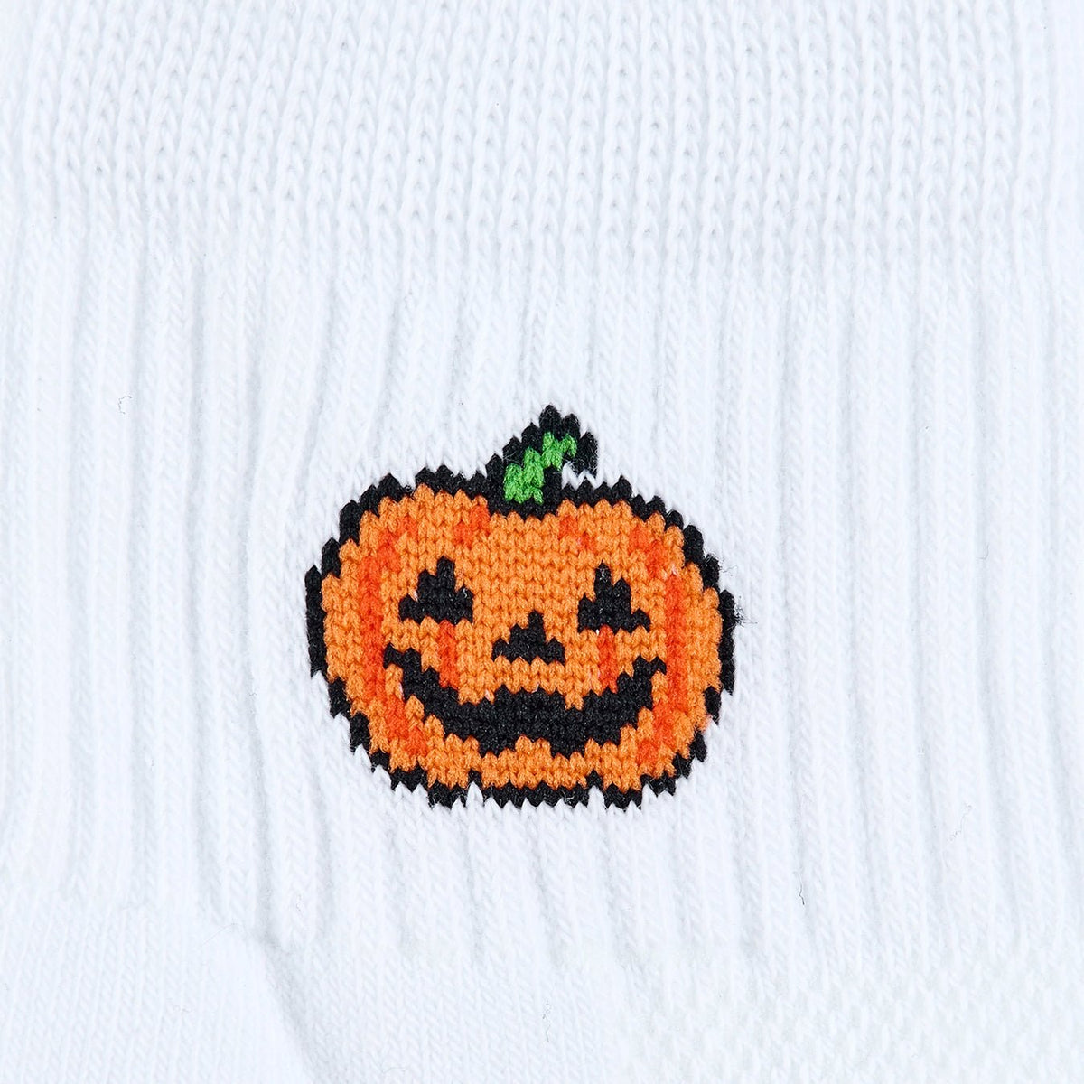 Del Campo Jack-O'-Lantern Halloween golf socks, white quarter socks with a grinning orange jack-o'-lantern, close-up of the knit jack-o'-lantern